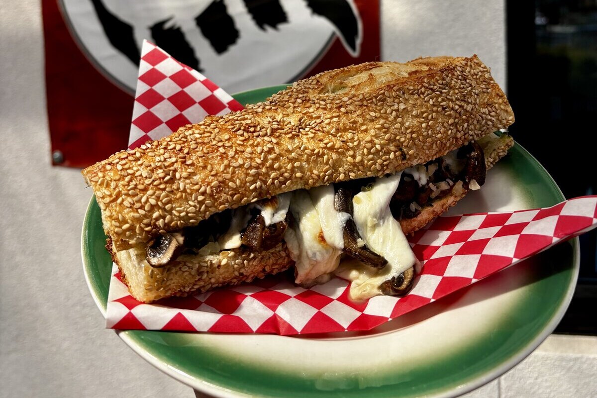 A warm, melty vegetarian mushroom sandwich on sesame semolina bread
